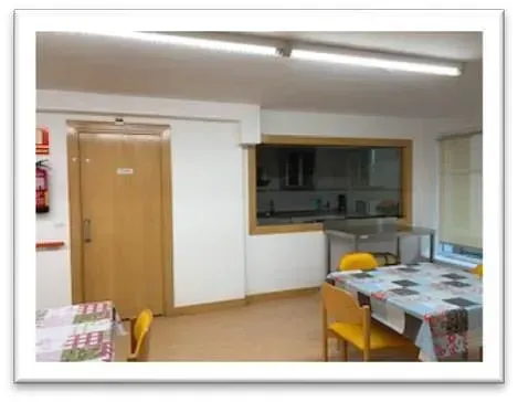 Una habitación con una mesa y sillas y una ventana.