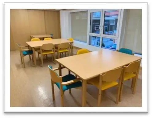 Una habitación con mesas y sillas y una ventana.