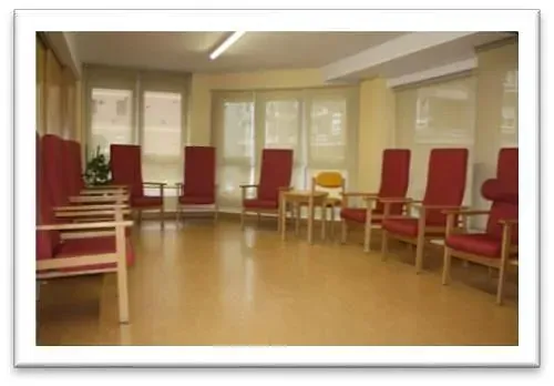 Una habitación con muchas sillas y mesas rojas.