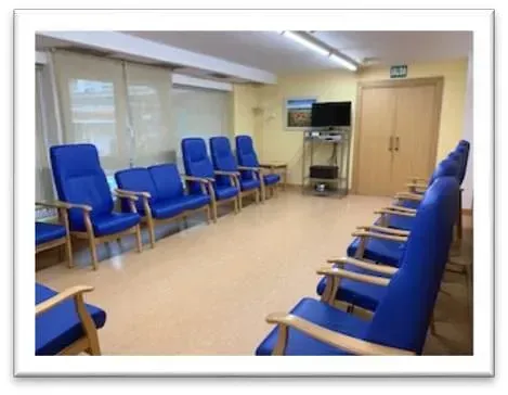 Una habitación llena de sillas azules y un televisor.