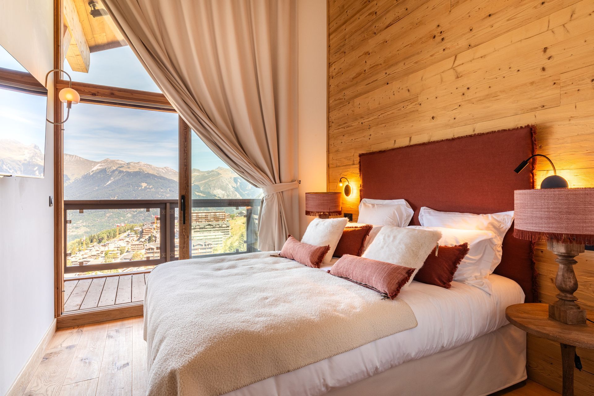 Il y a un grand lit au milieu de la pièce avec vue sur les montagnes.