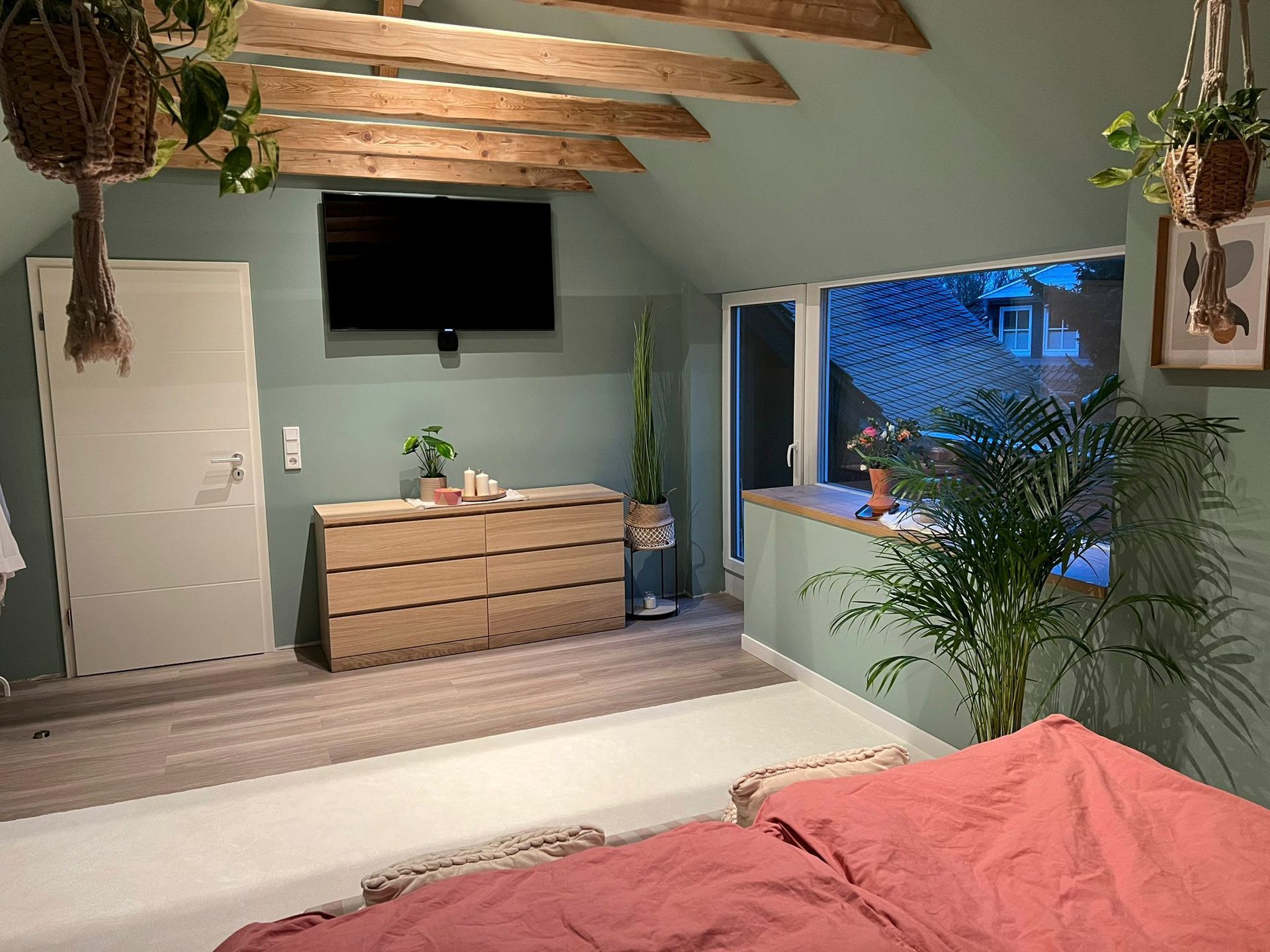ein Schlafzimmer mit Bett, Kommode und Fernseher.