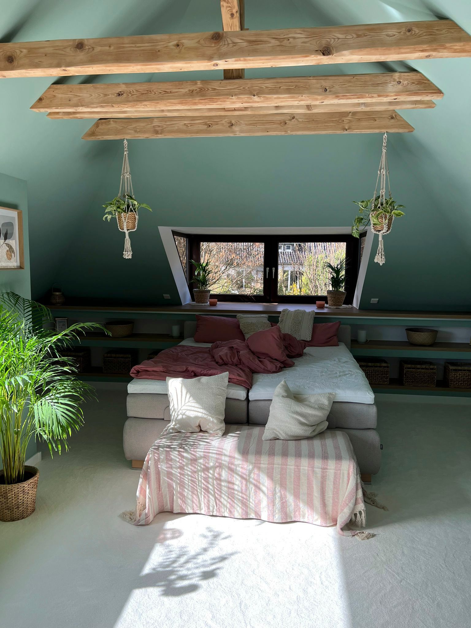 ein Schlafzimmer mit einem Bett und einem Fenster im Dachgeschoss.