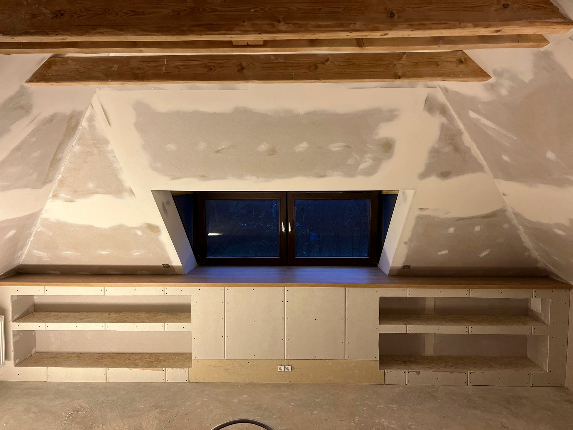 ein Raum mit einem Fenster und Regalen darin