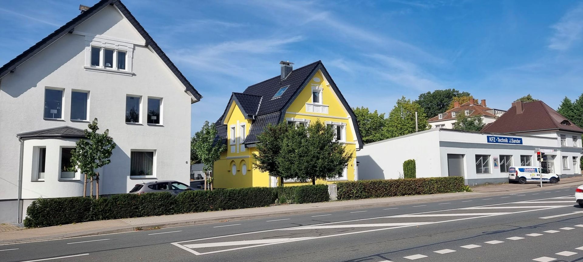 Ein gelb-weißes Haus steht neben einem weißen Haus