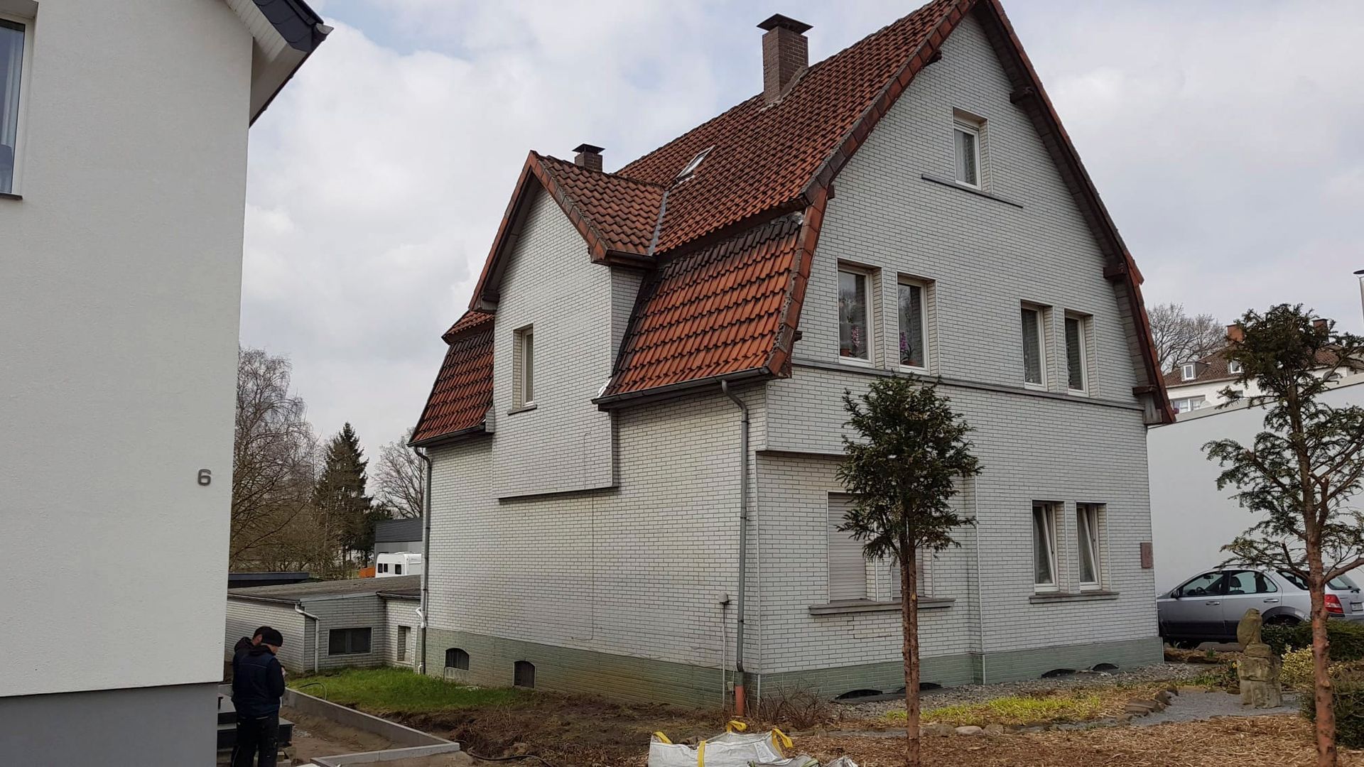 ein großes weißes Haus mit einem roten Ziegeldach