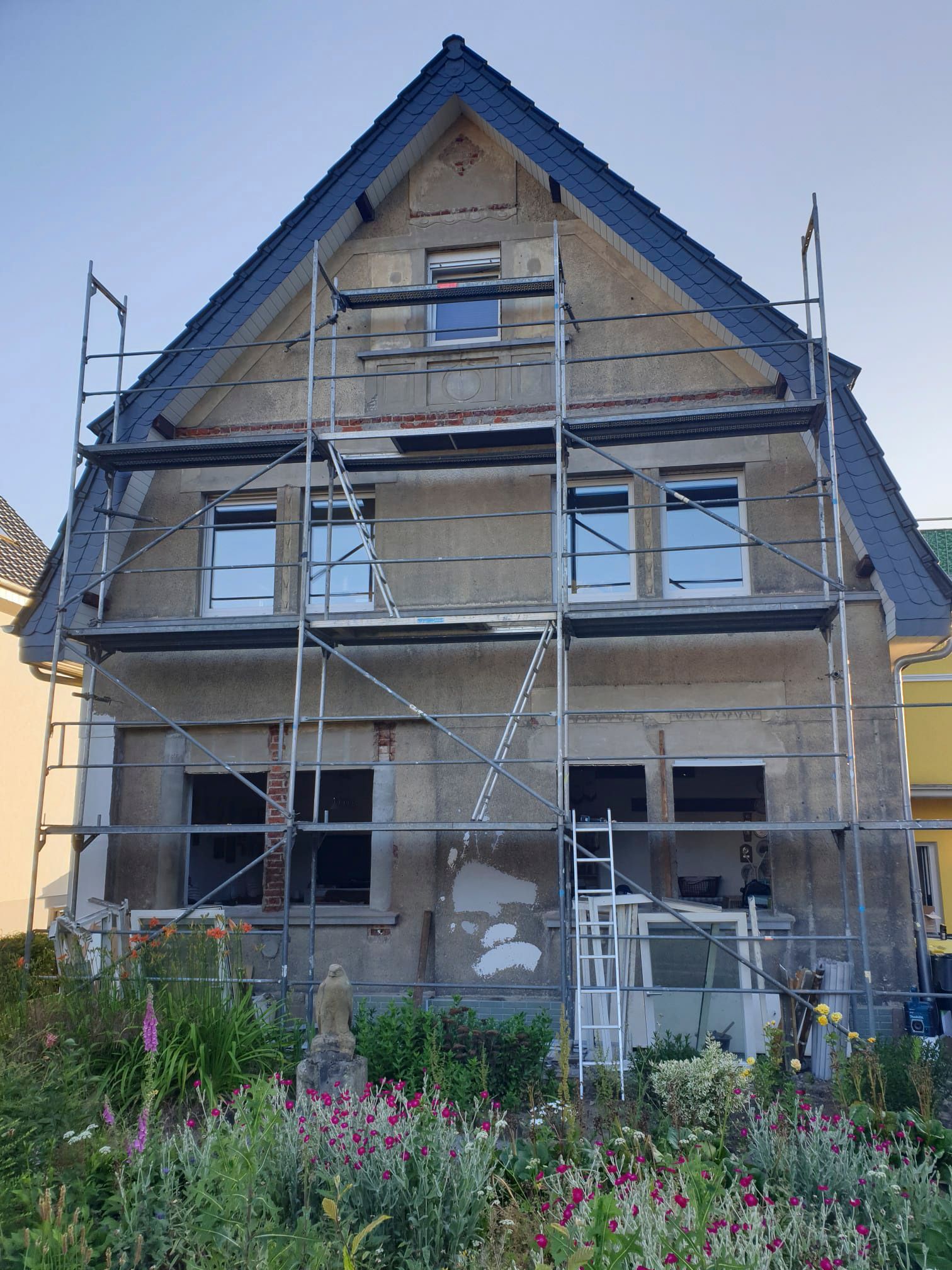 Es wird ein Haus gebaut, das von einem Gerüst umgeben ist.