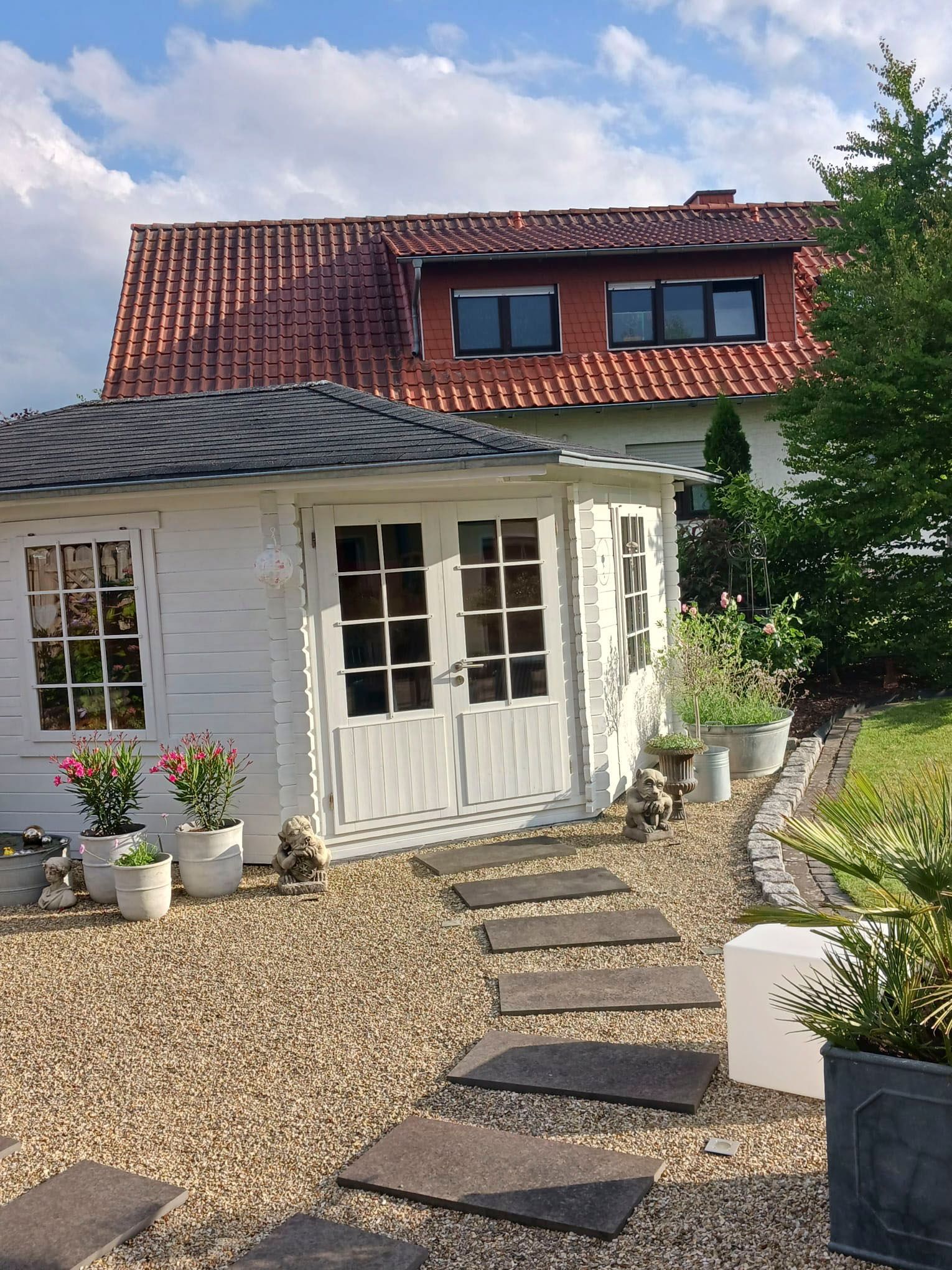 ein weißes Haus mit rotem Dach und einem Gehweg, der dorthin führt