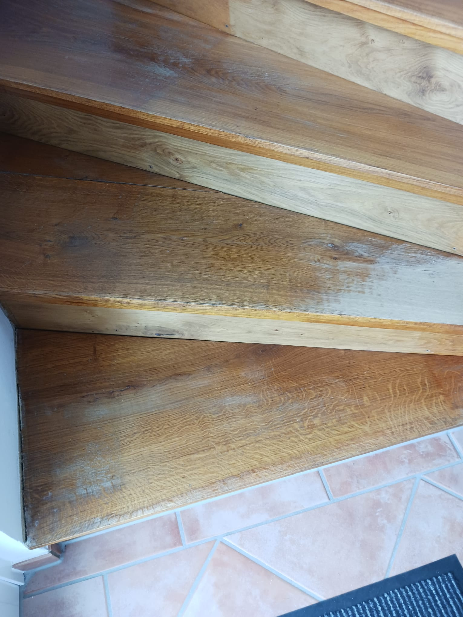 Eine Nahaufnahme einer Holztreppe mit Fliesenboden.