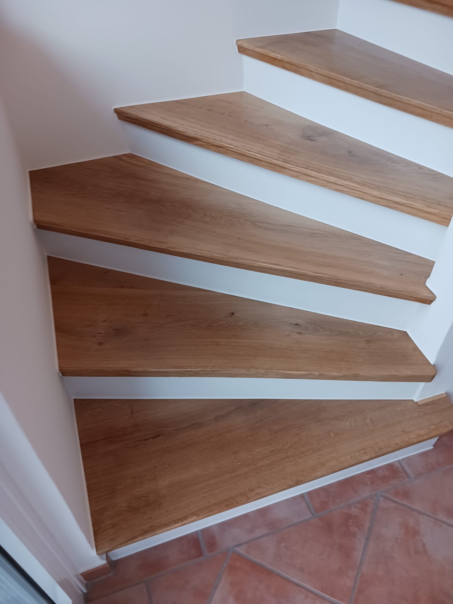 eine Nahaufnahme einer Holztreppe mit weißen Stufen.