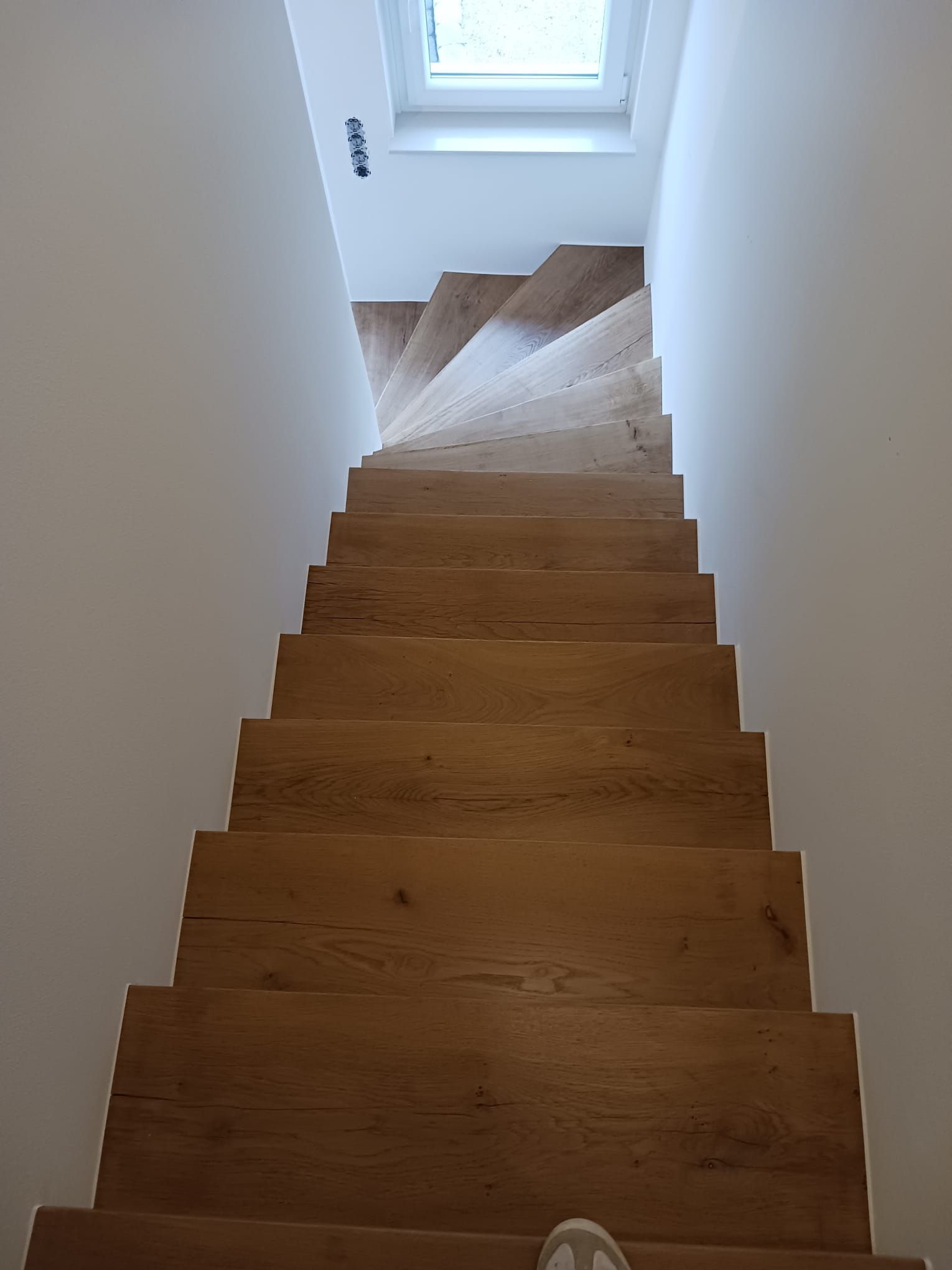 Eine Person geht eine Holztreppe hinunter.