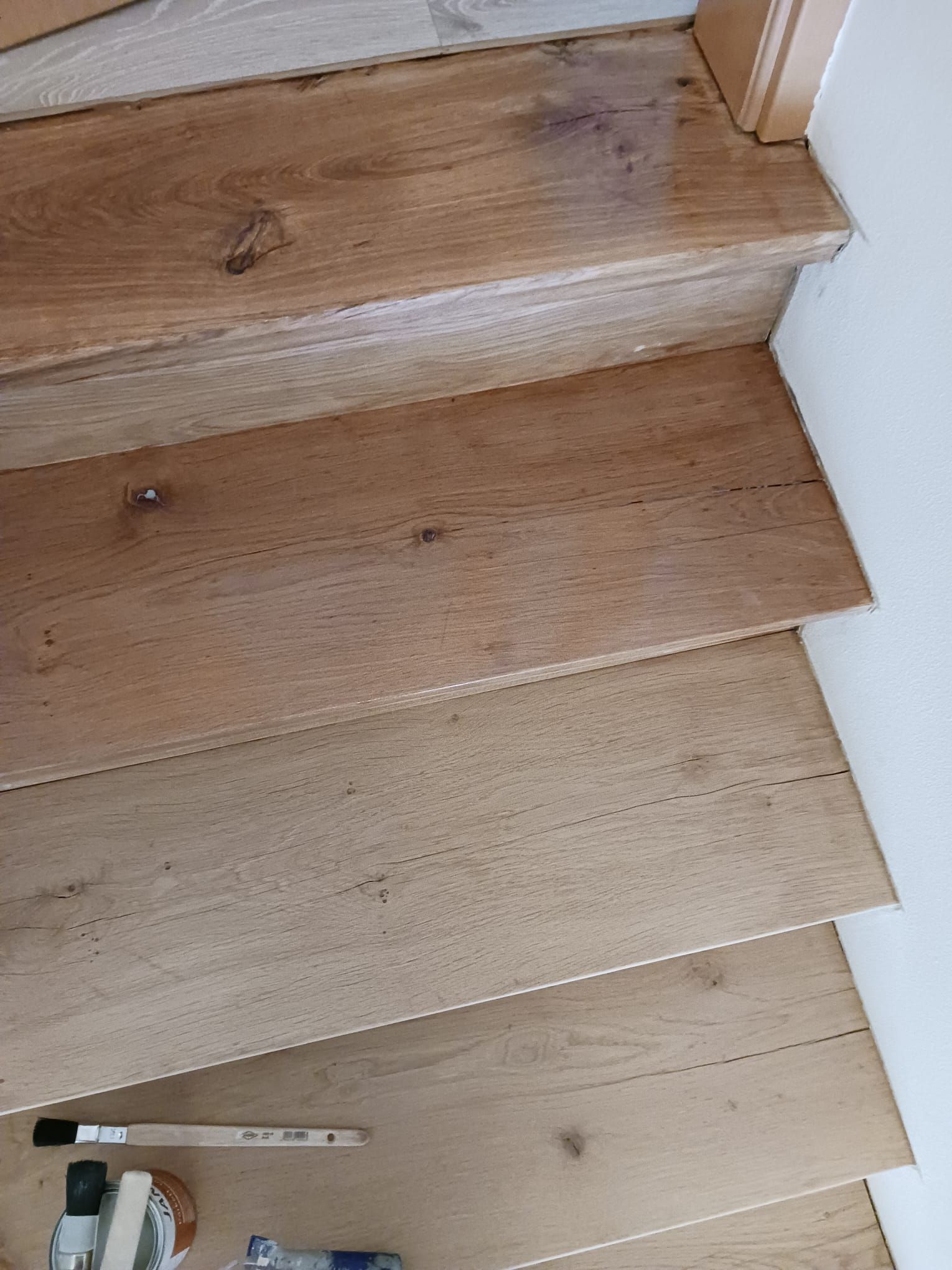 Eine Nahaufnahme einer Holztreppe mit einer Bürste darauf.