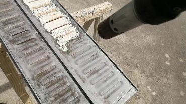 Porte de casier gris en train d'être décapé