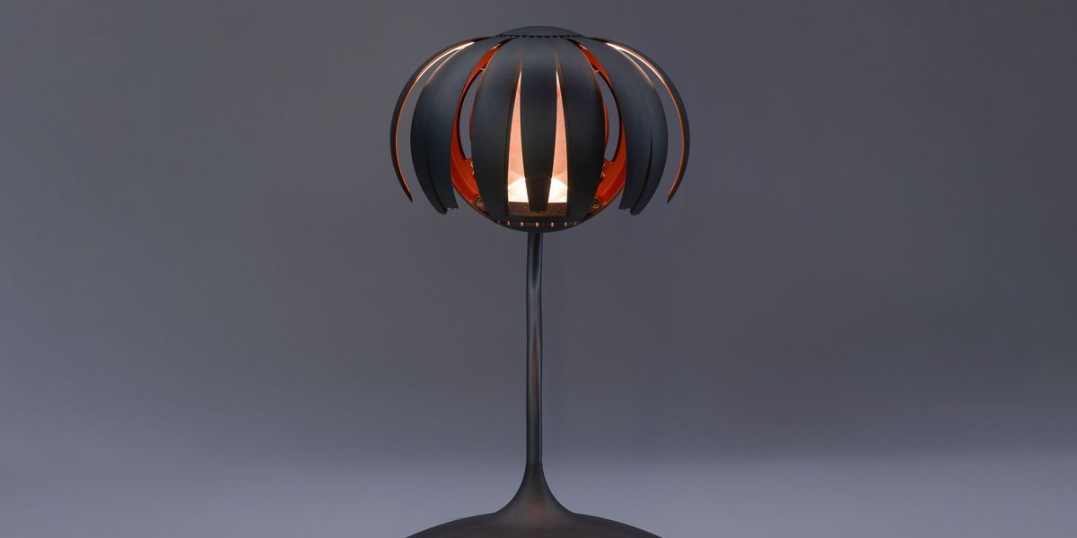 Auf einem Tisch steht eine schwarze Lampe mit rotem Schirm - Ent-werft-Designleuchte monoa3 mit Gestensteuerung
