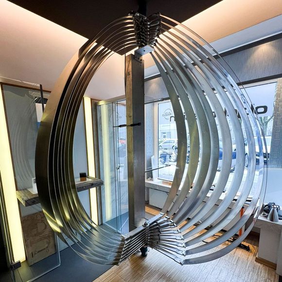 In einem Raum hängt eine große Metallskulptur von der Decke - Ent-werft-Designleuchte monoa3 mit Gestensteuerung