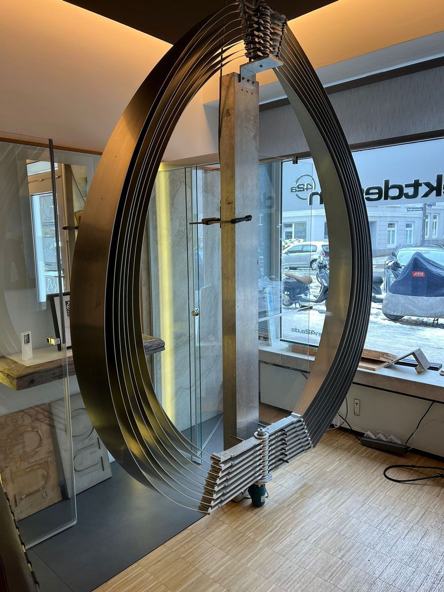 In einem Raum hängt ein großer Metallring von der Decke - Ent-werft-Designleuchte monoa3 mit Gestensteuerung