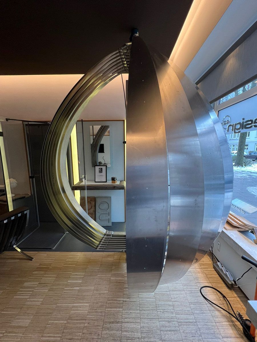 ein Raum mit einer Edelstahlskulptur in der Mitte - Ent-werft-Designleuchte monoa3 mit Gestensteuerung