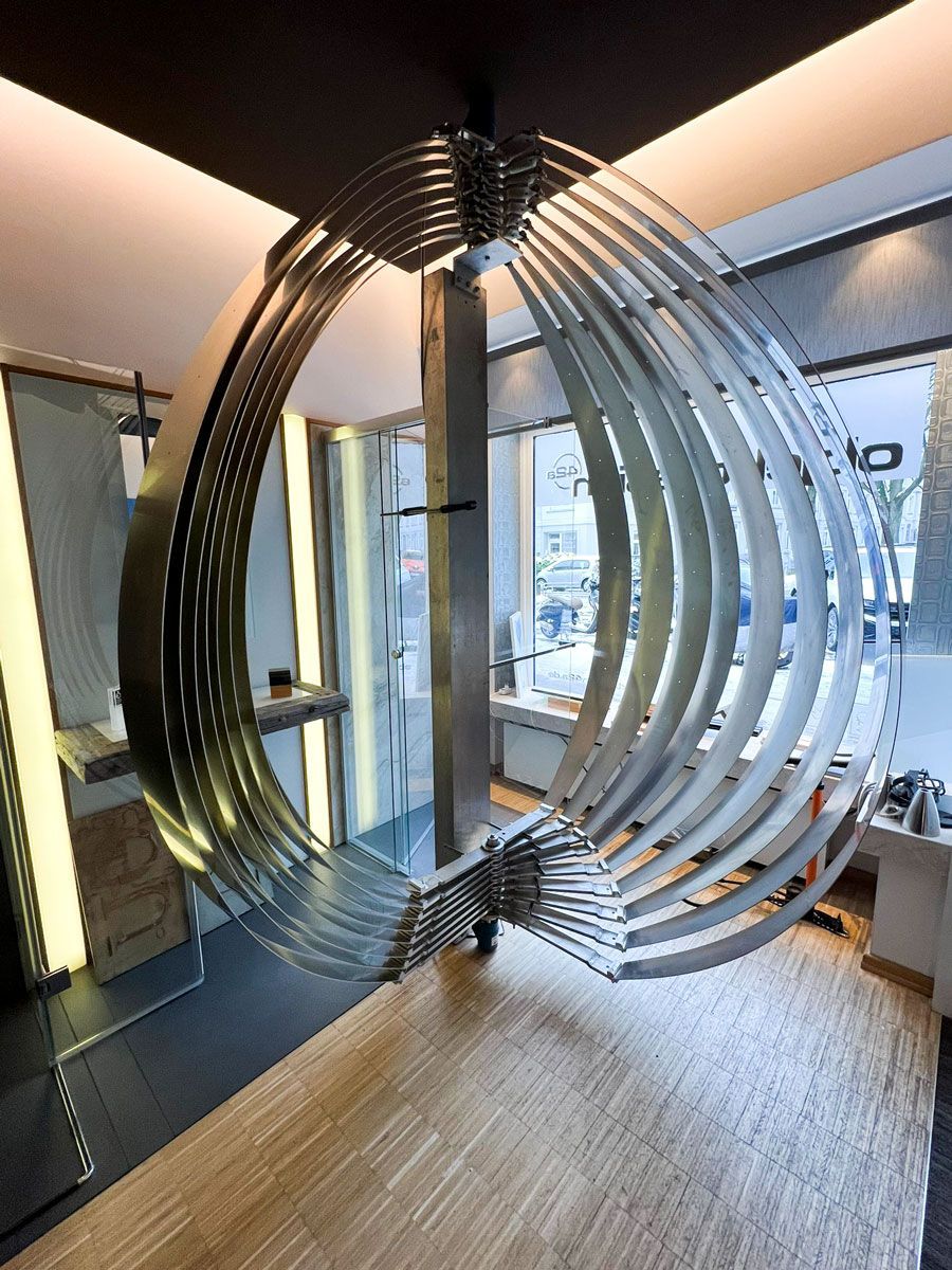 In einem Raum hängt eine große Metallskulptur von der Decke - Ent-werft-Designleuchte monoa3 mit Gestensteuerung