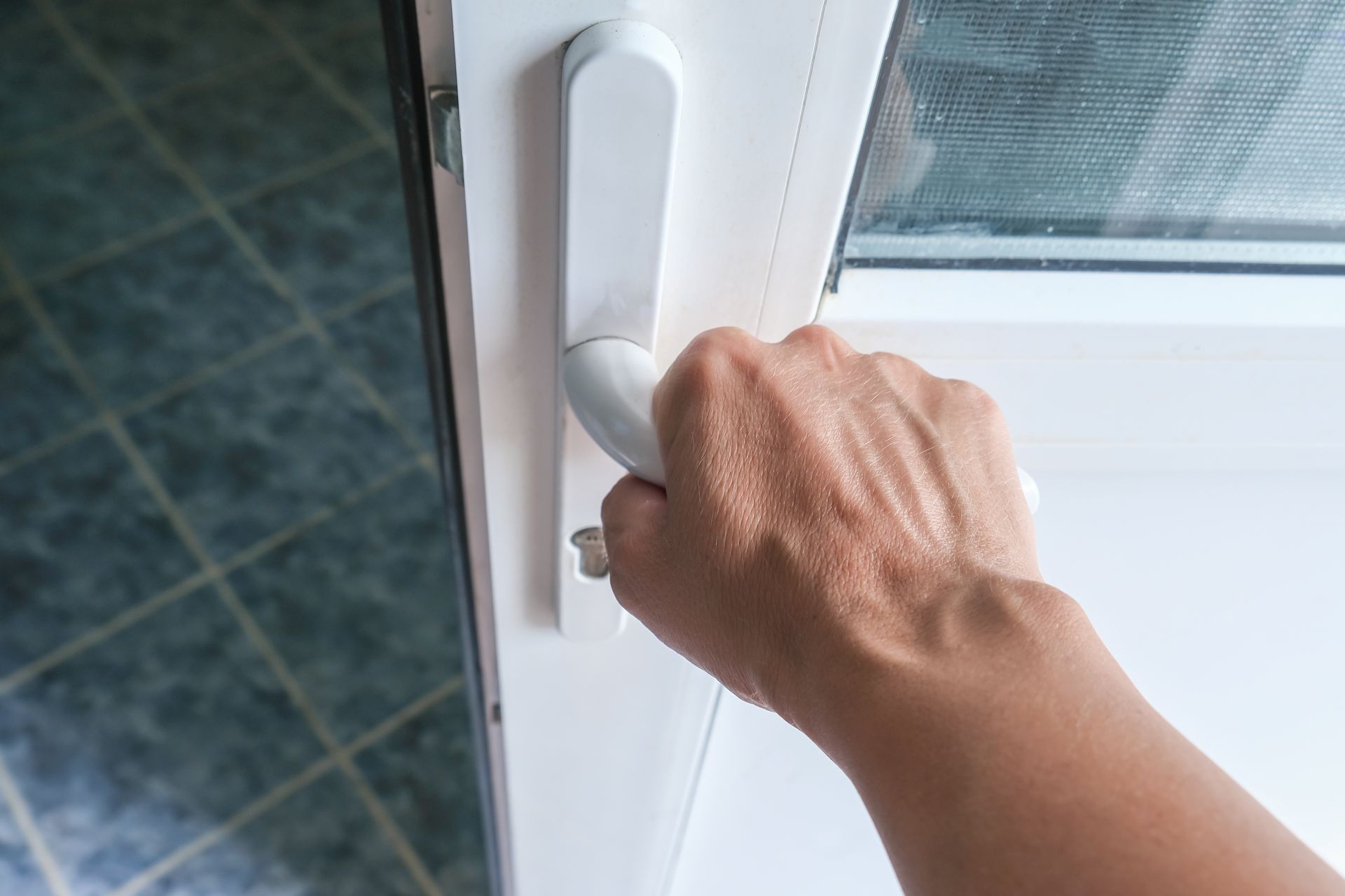 Main appuyant sur la poignée d'une porte