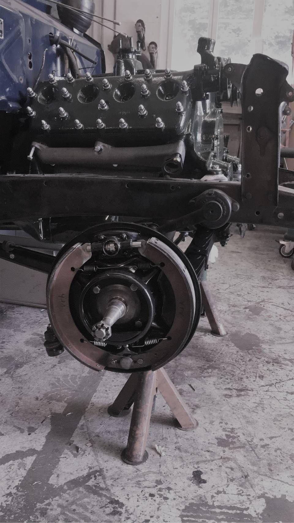 Schwarzes Autochassis und Motor in der Werkstatt mit einem Rad.
