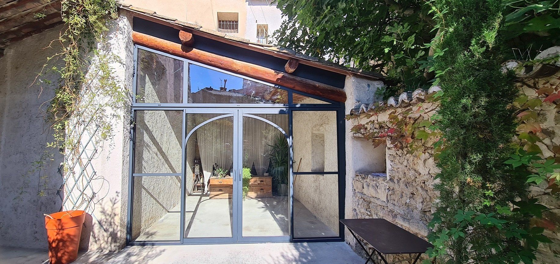 Fermeture de terrasse avec une baie coulissante en Aluminium et petits bois cintrés
