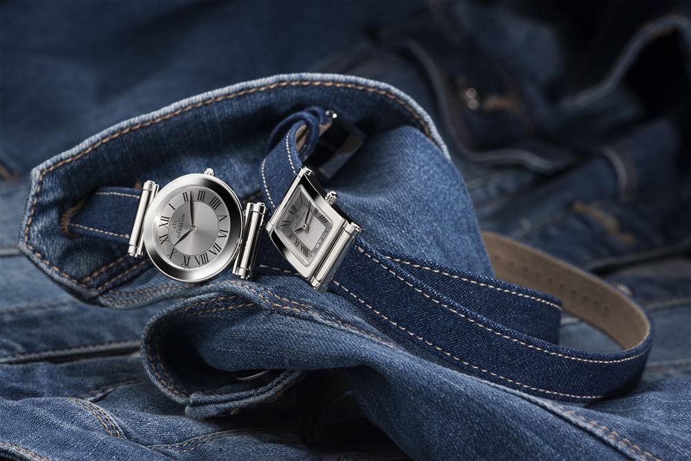 Eine Uhr liegt auf einer Bluejeans