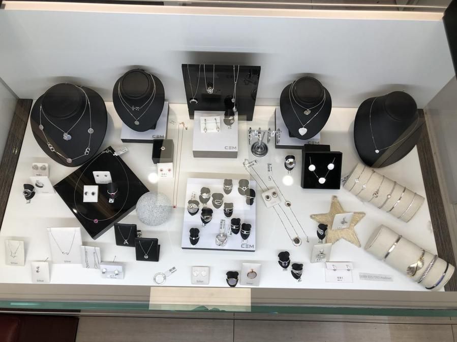 Eine Vitrine mit viel Schmuck, darunter Halsketten und Ringe.