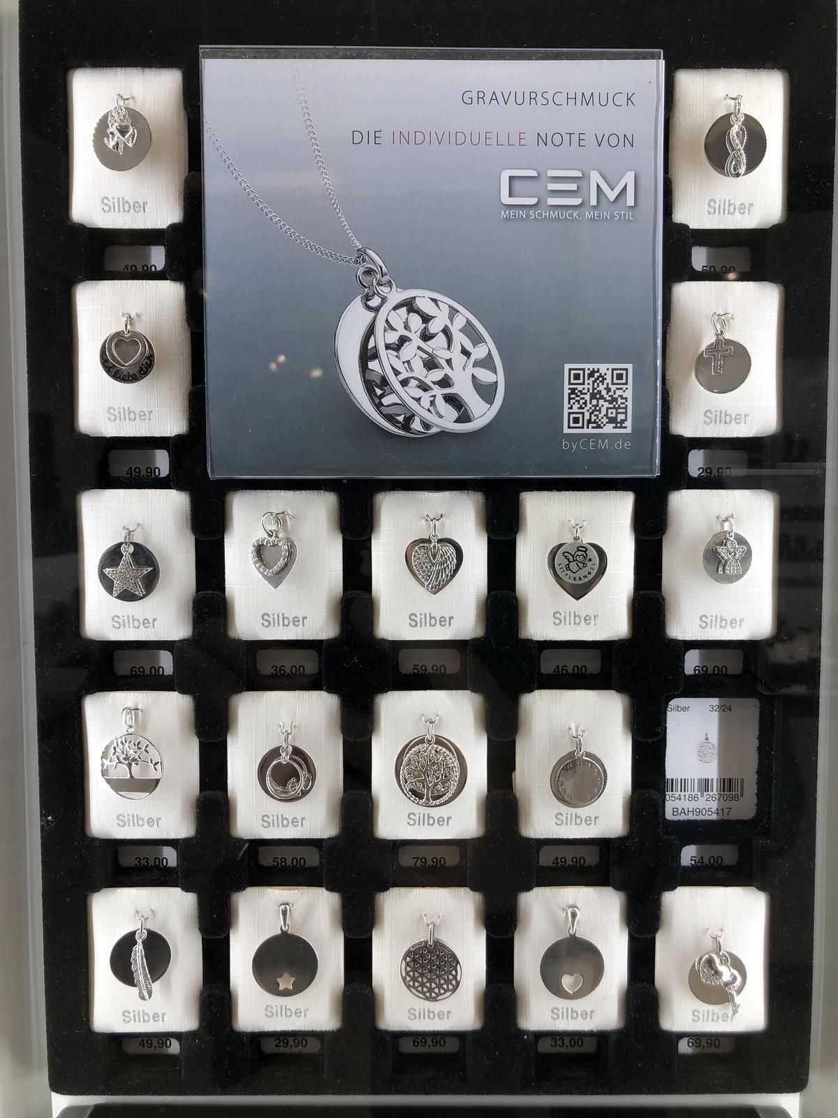 Eine Auswahl an Silberanhängern mit dem Wort „Cem“ darauf