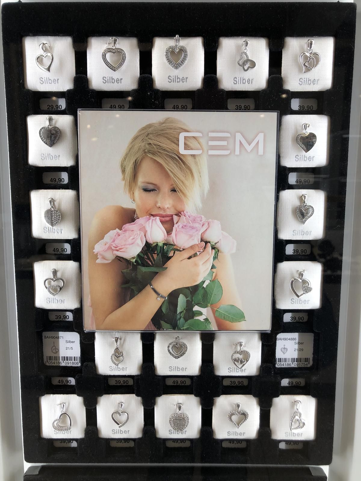 Eine Frau hält einen Strauß rosa Rosen in einem Rahmen mit der Aufschrift „Cem“