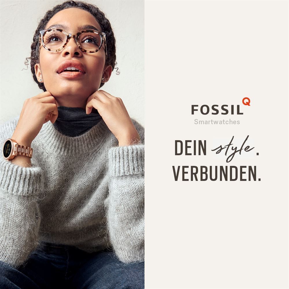 Eine Frau mit Brille und Pullover trägt eine Smartwatch von Fossil.