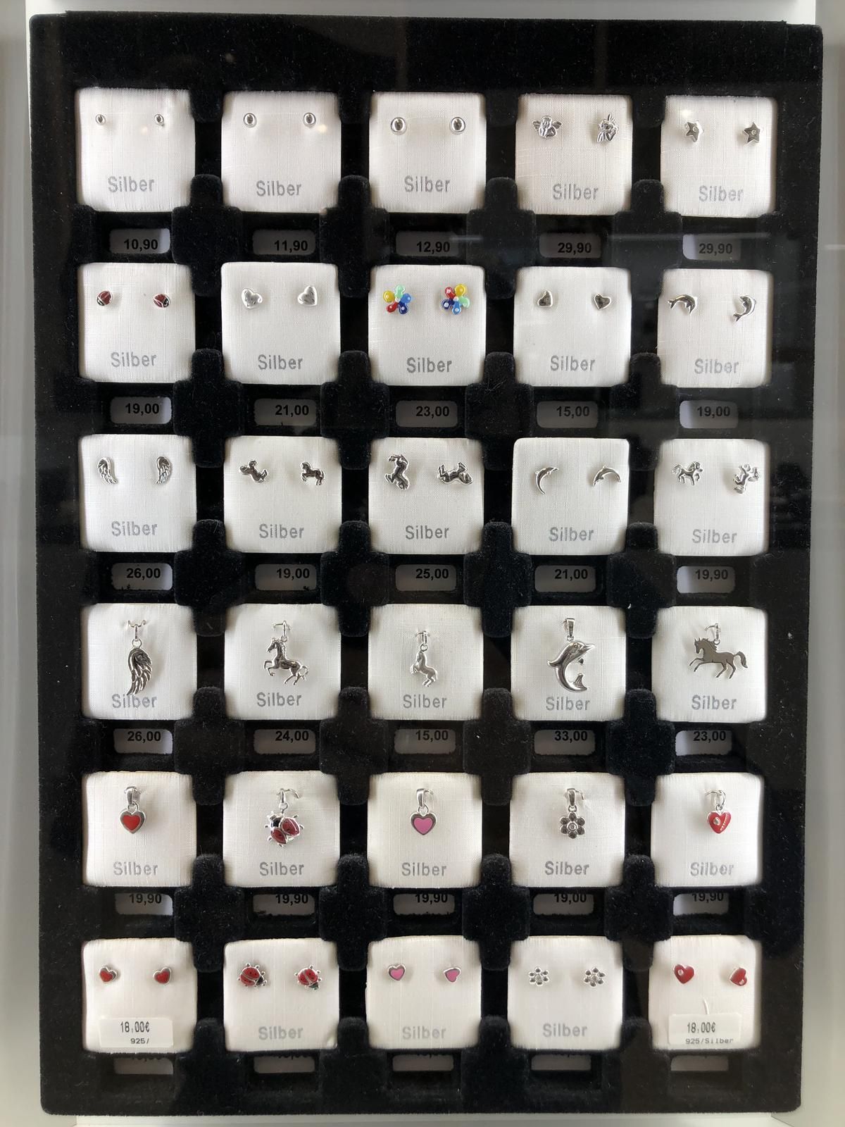 In dieser Vitrine sind viele unterschiedliche arten von ohrringen zu sehen.