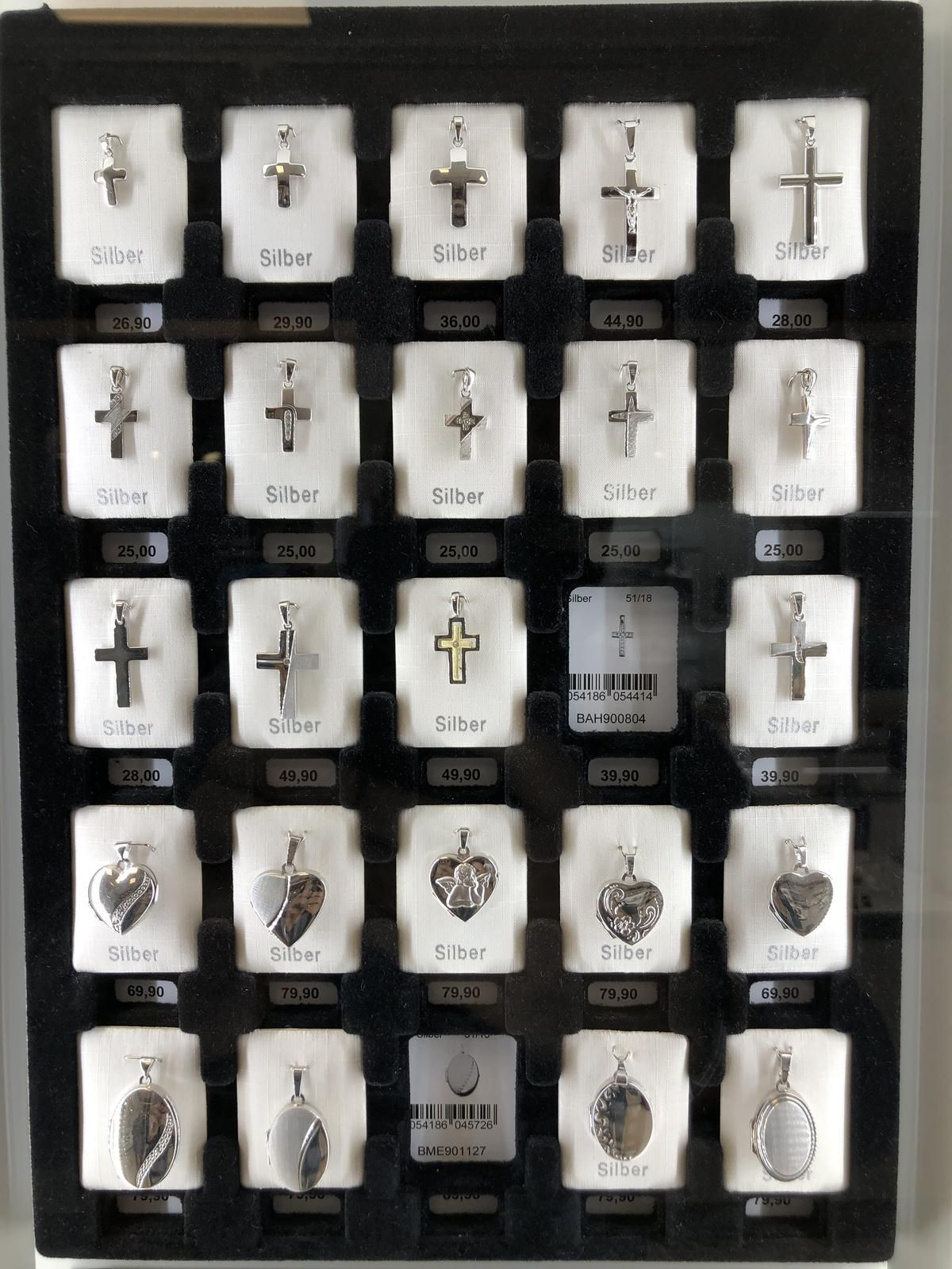 Eine Ausstellung verschiedener Anhänger, darunter Kreuze und Herzen