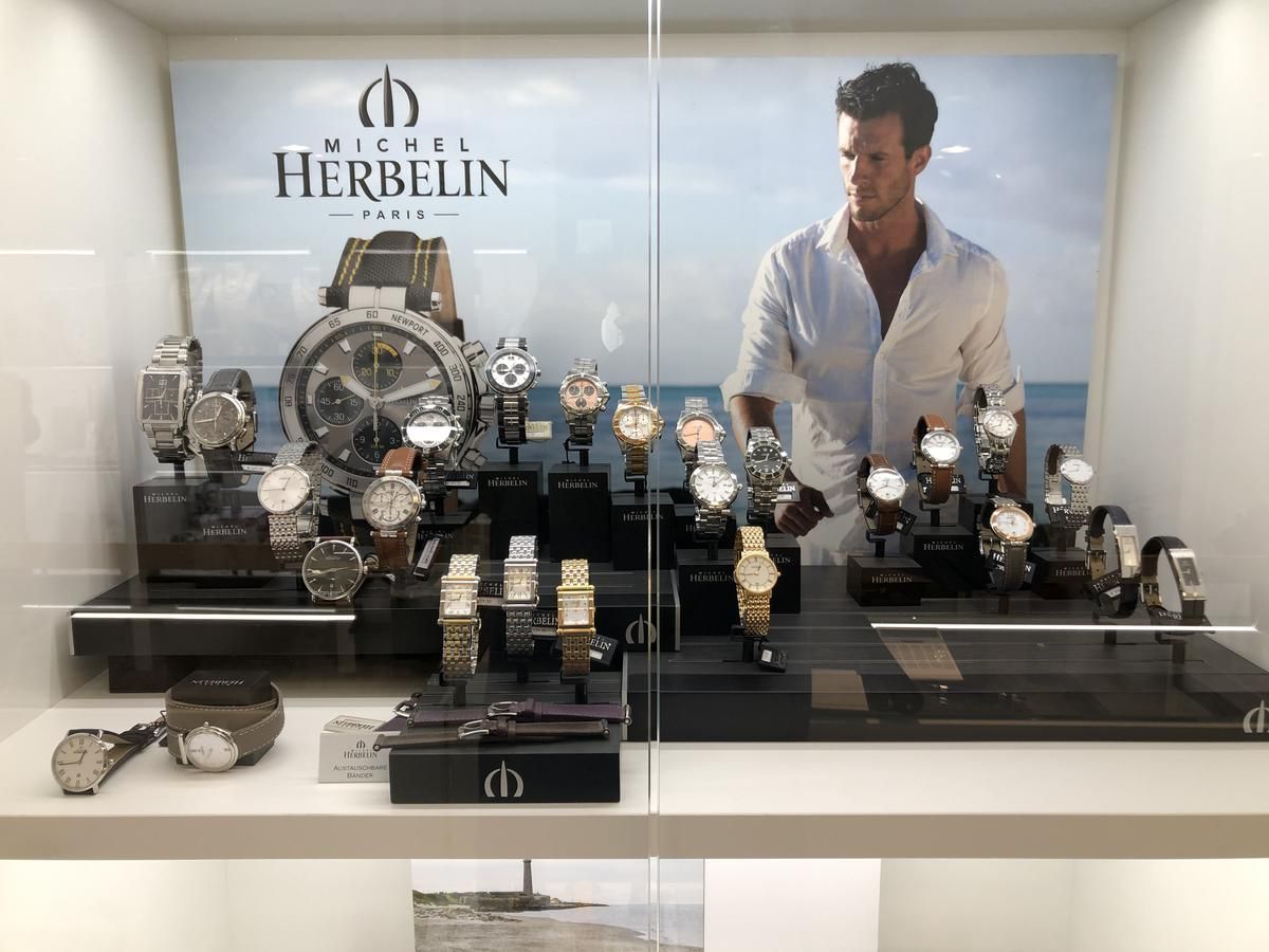 Ein Mann steht vor einer Uhrenauslage in einem Schaufenster.