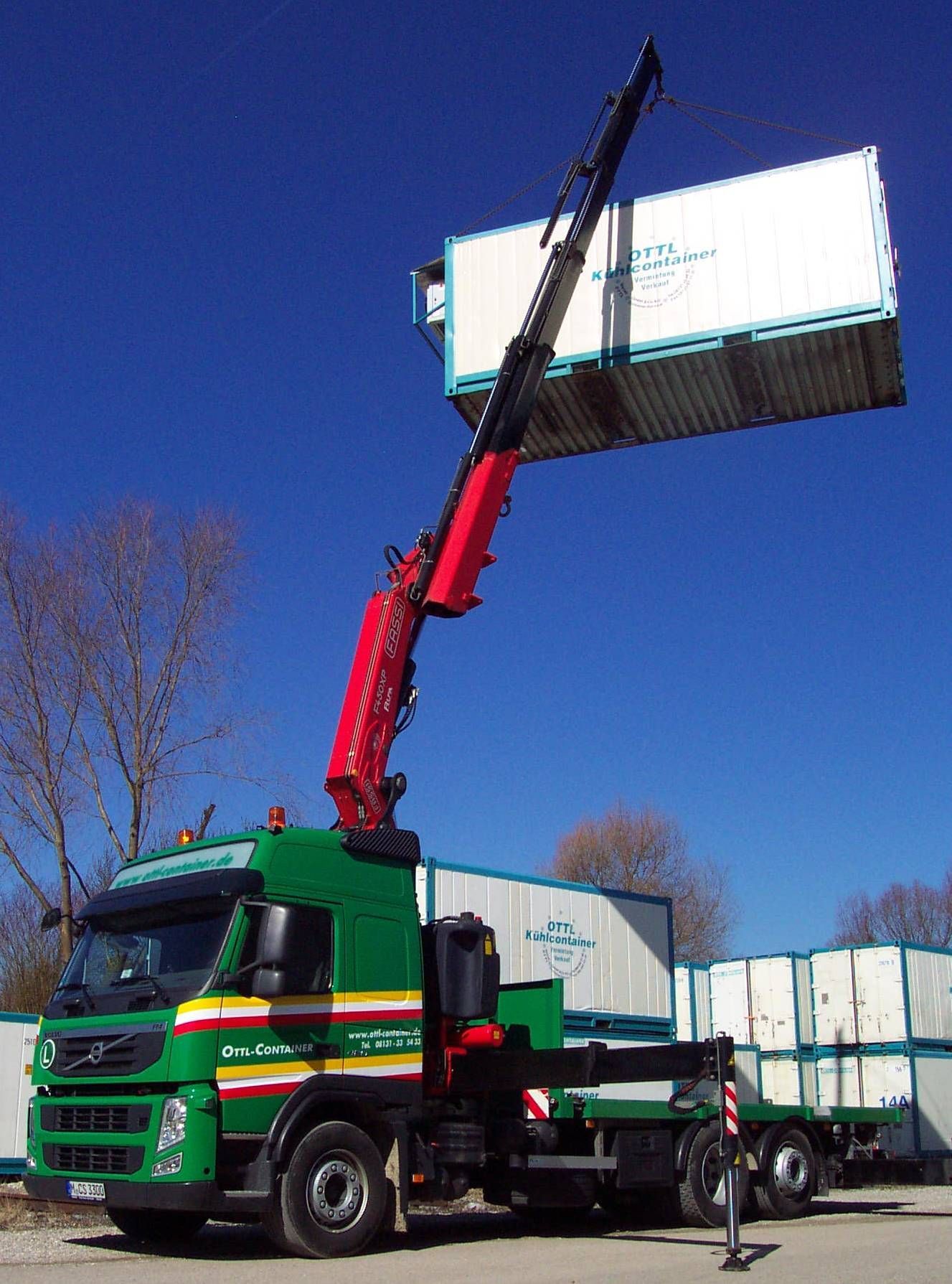 LKW von OTTL-CONTAINER mit Kran, der einen Containern anhebt