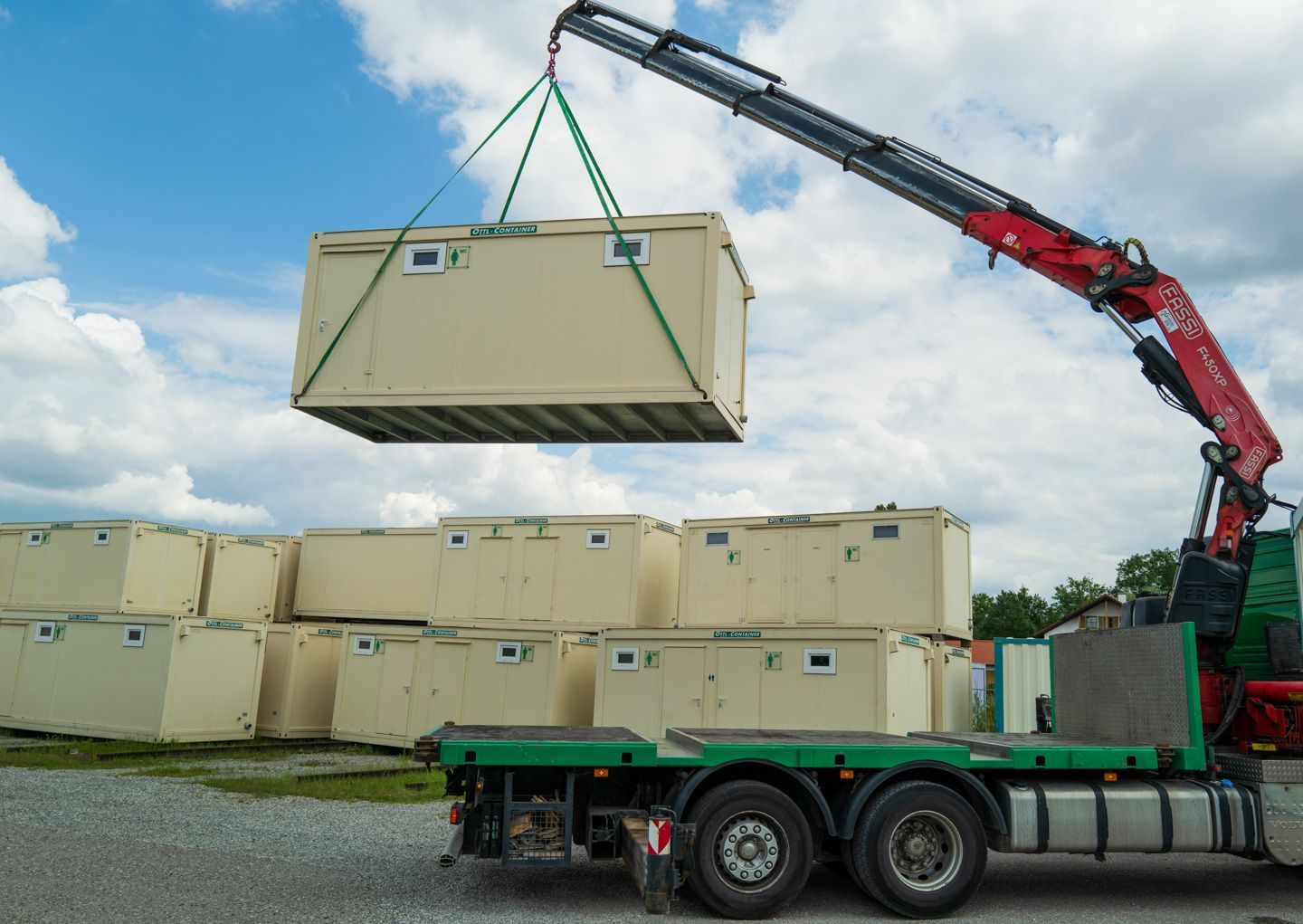Ein Kran hebt einen Container von der Ladefläche eines LKWs
