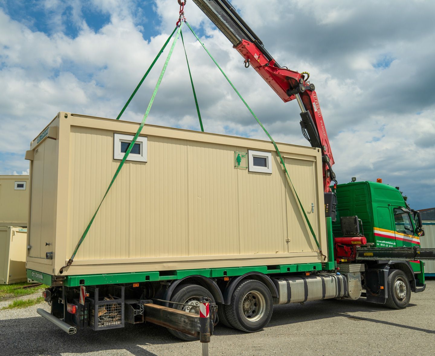 LKW von OTTL-CONTAINER, ein Kran platziert einen Container auf der Ladefläche