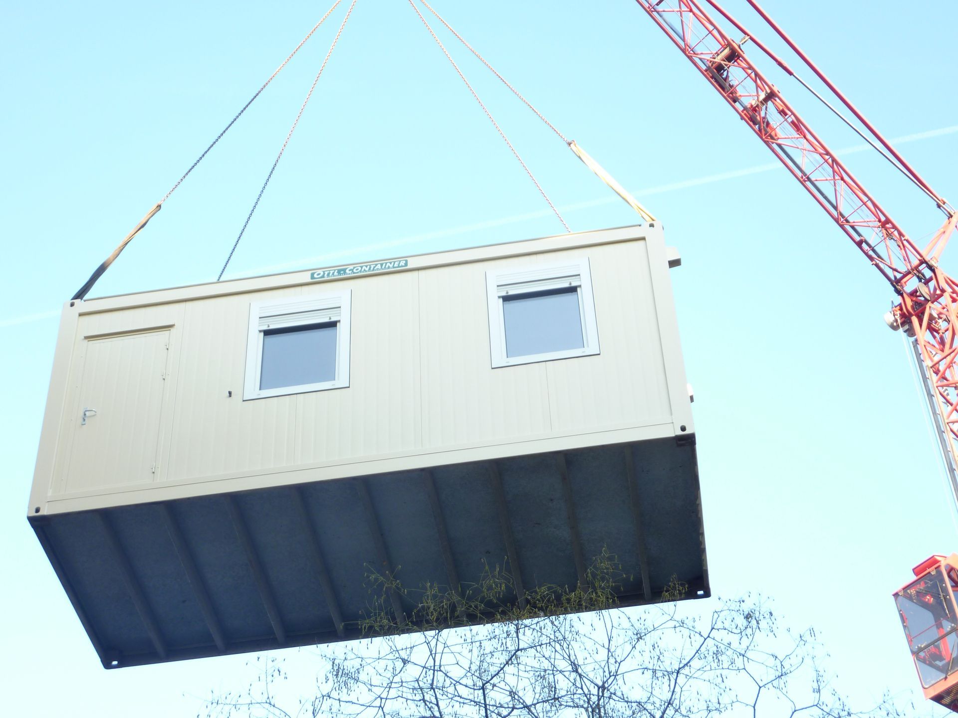 Ein Kran hebt eine Bürocontainer von OTTL-CONTAINER an