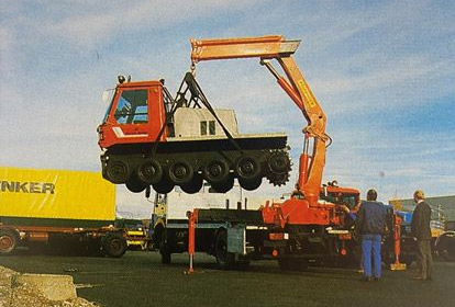 Spezialtransport - ein LKW-Kran hebt ein Kettenfahrzeug an.