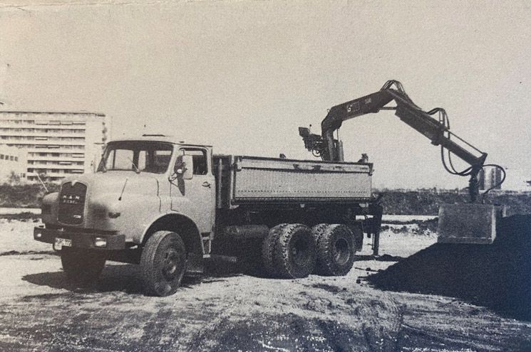Ein Bagger lädt Erde auf die Ladefläche eines großen Muldenkippers auf einer Baustelle
