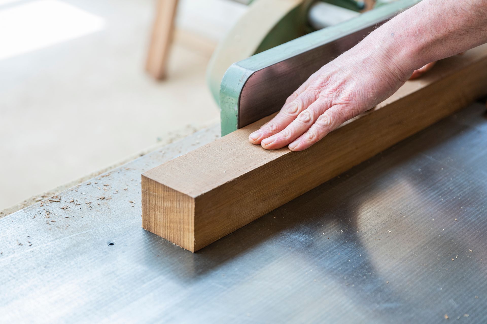 Main du menuisier qui travaille une pièce de bois