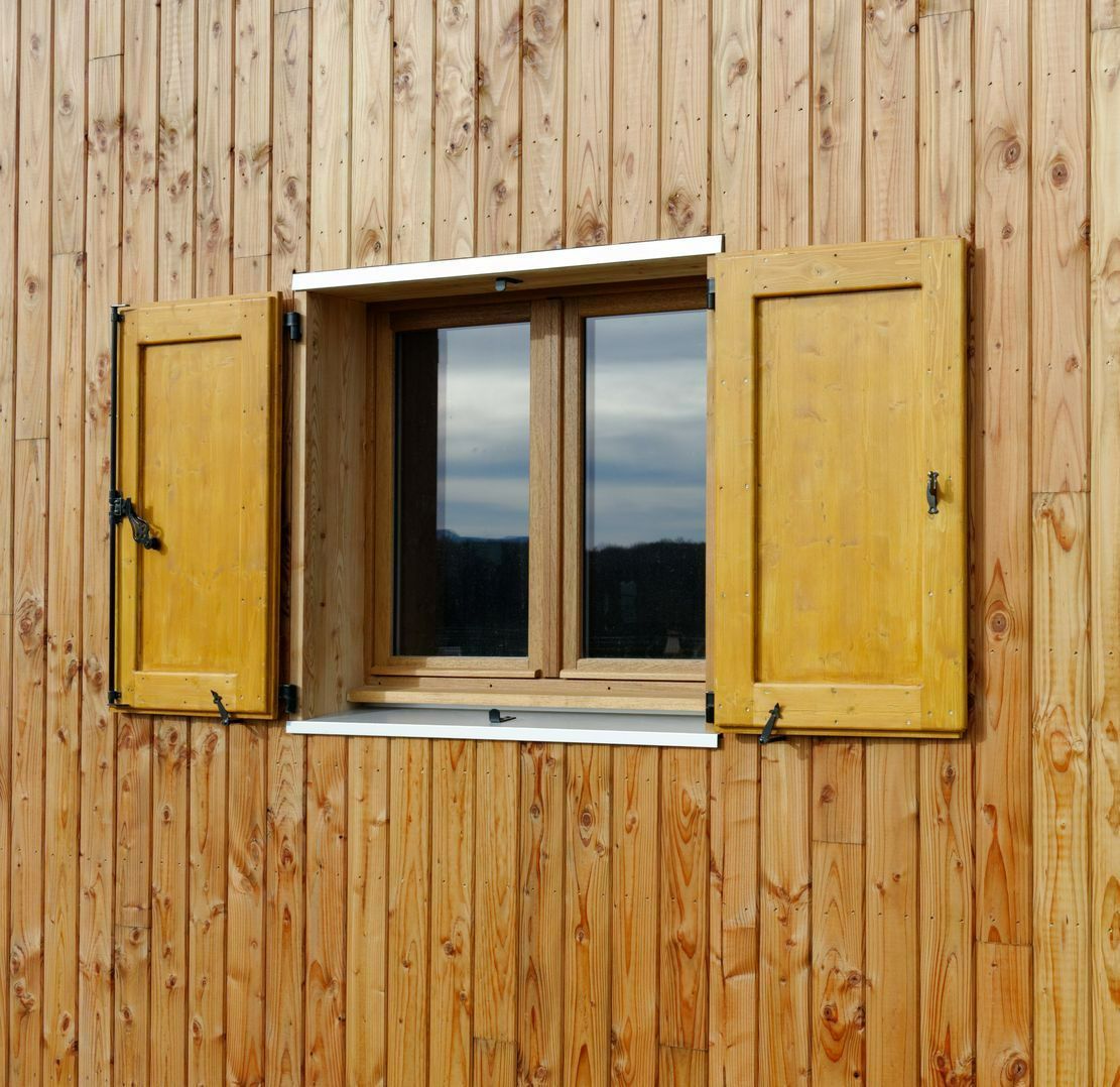 Volets en bois sur maison avec bardage bois