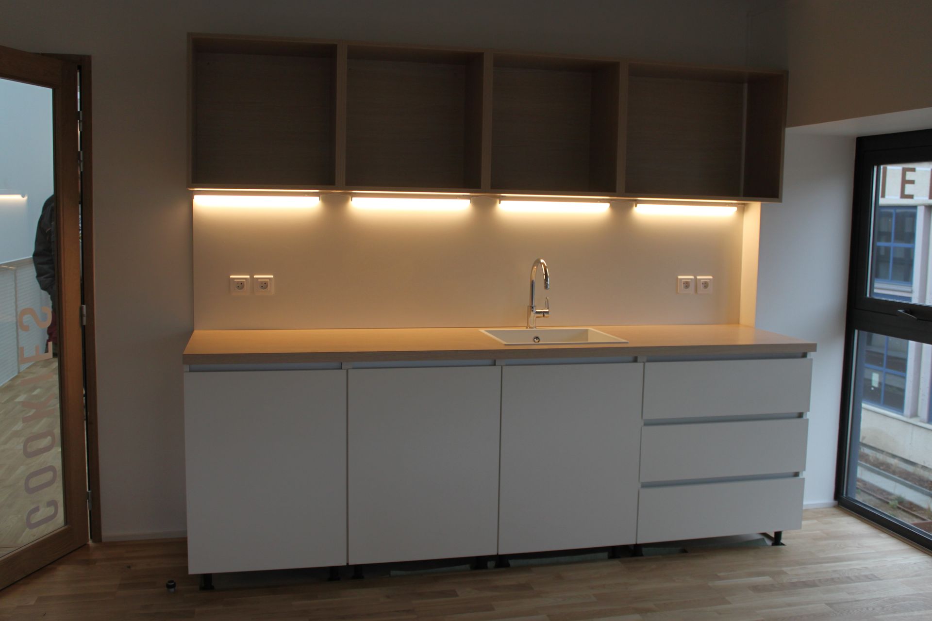 Cuisine sur mesure blanche en bois éclairée par des LED