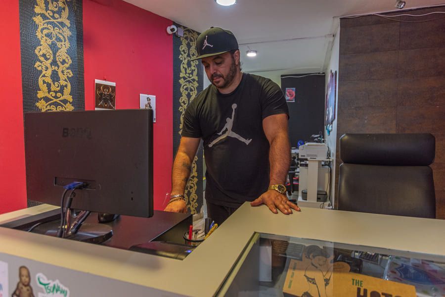 Un hombre está de pie en un mostrador frente a una computadora.