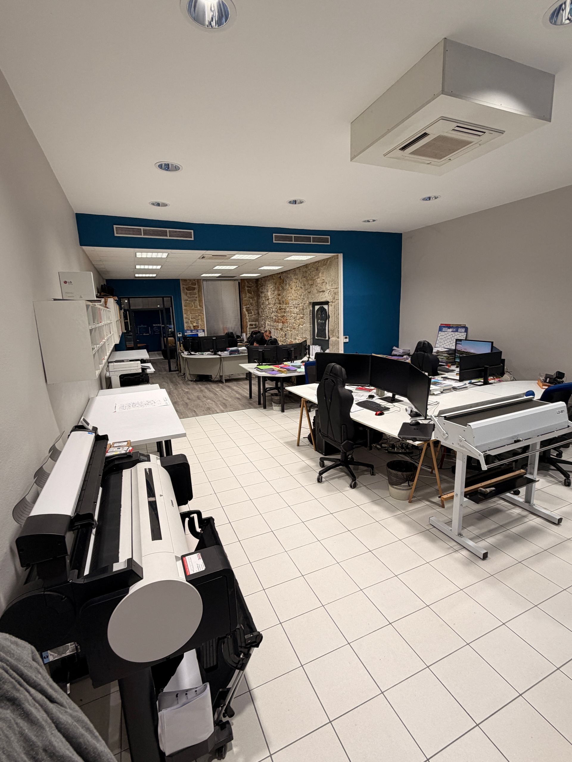 Un espace de bureau avec de grandes imprimantes 