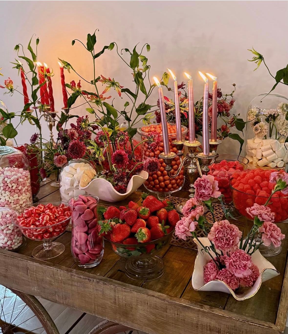 Un banco de mimbre está situado delante de un arco floral.