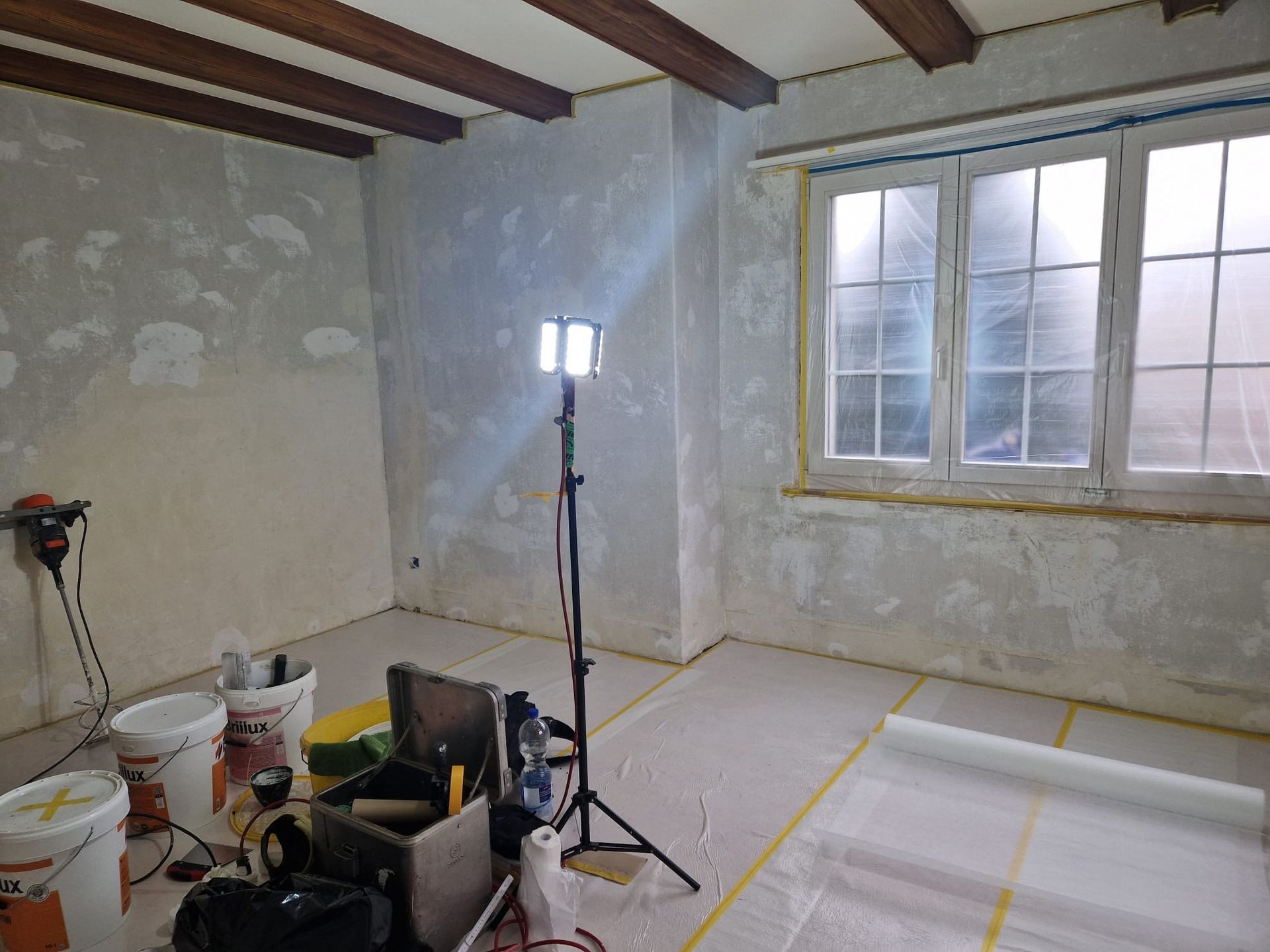 Ein Raum mit vielen Farbeimern und einer Lampe.