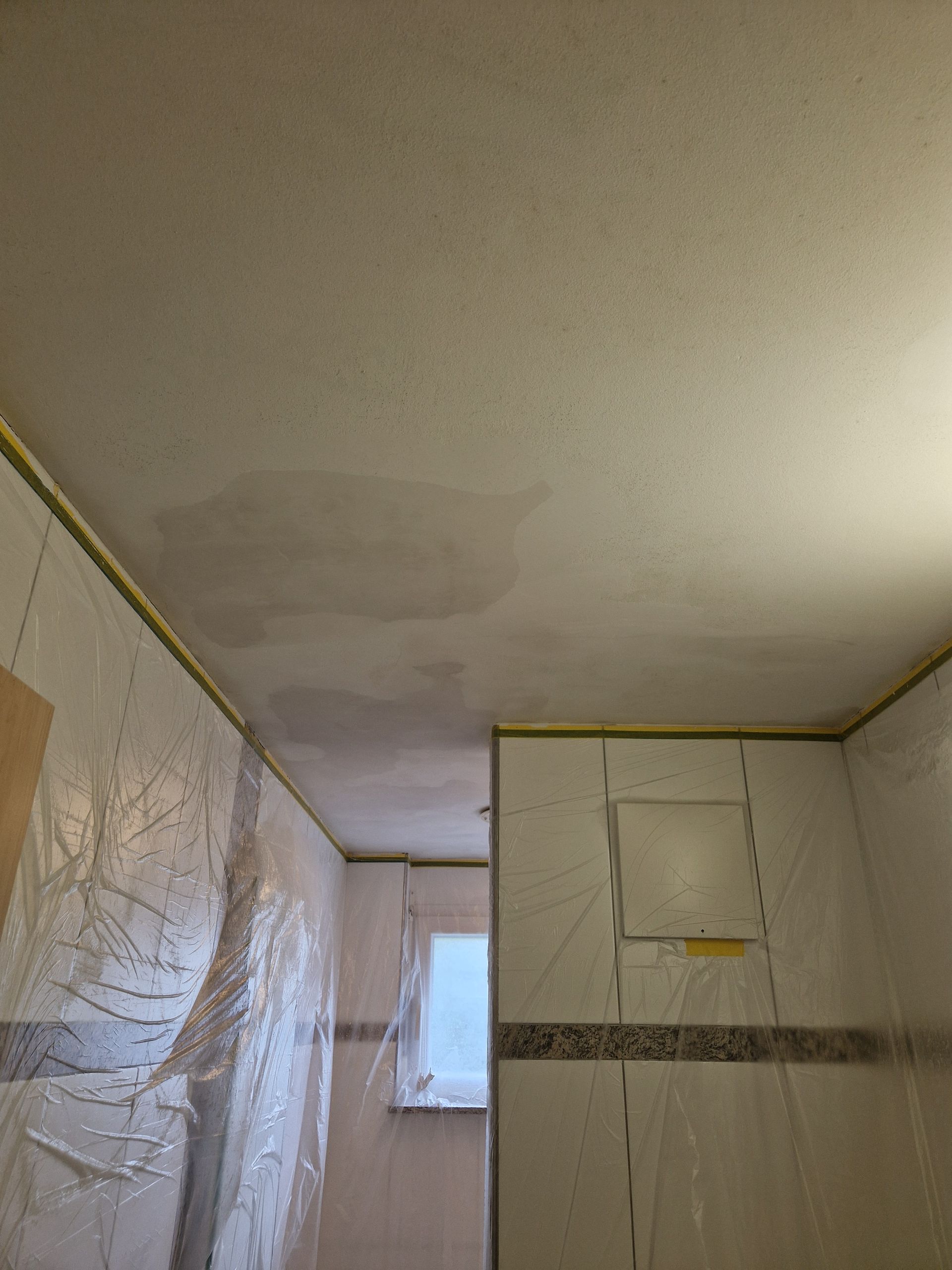 Ein Badezimmer mit einer Decke, die mit Plastik verkleidet ist.