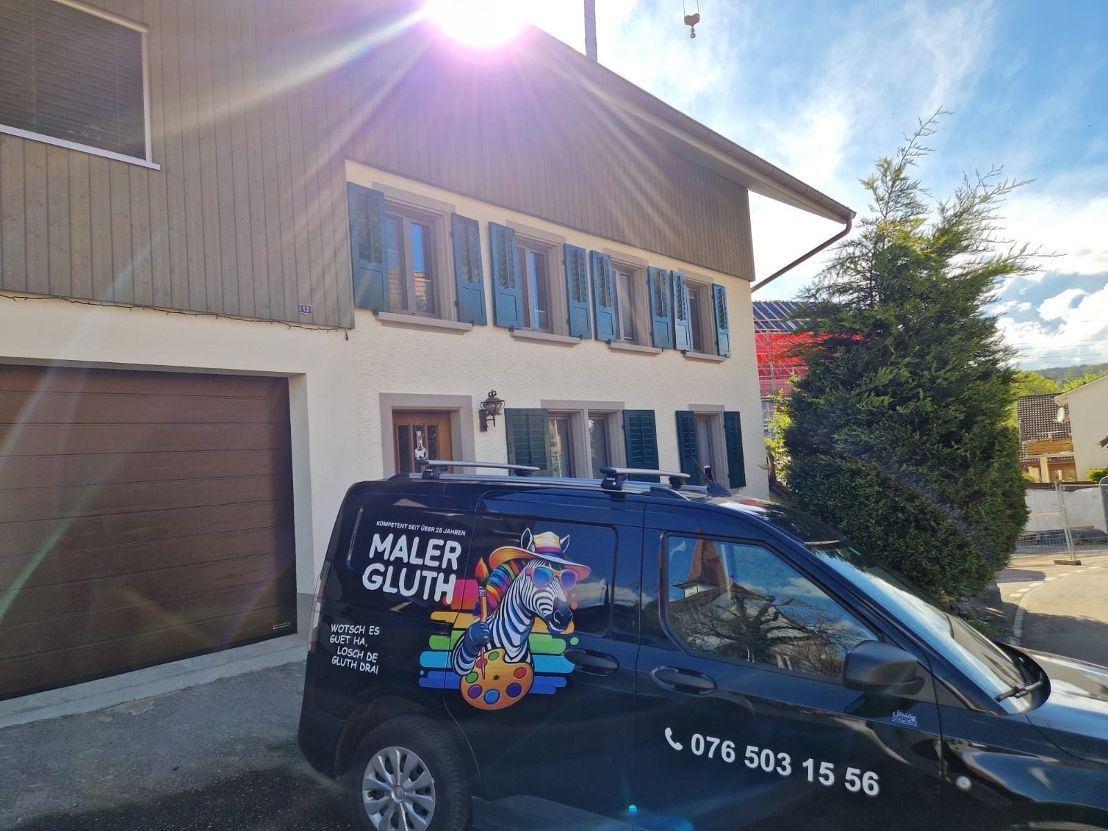 Vor einem Gebäude parkt ein schwarzer Lieferwagen.