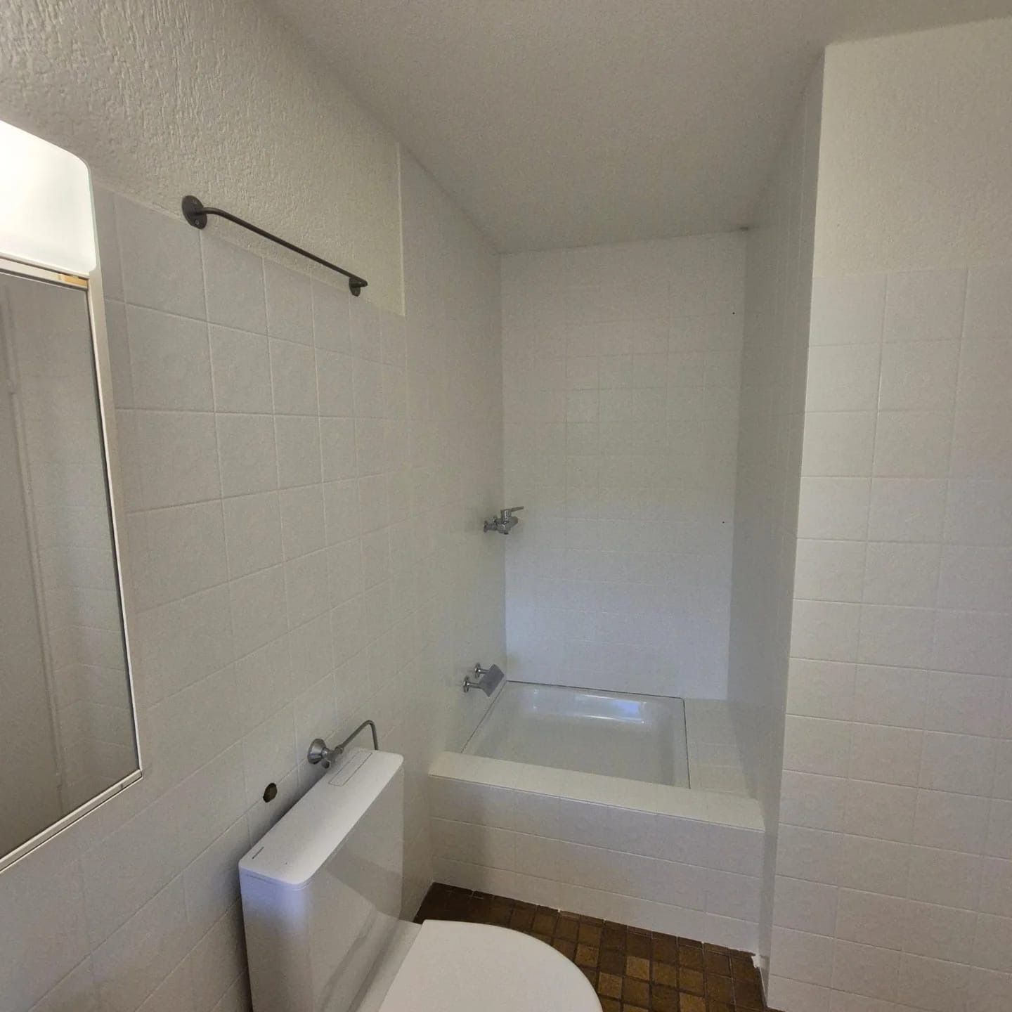 Ein Badezimmer mit Toilette, Badewanne und Spiegel.