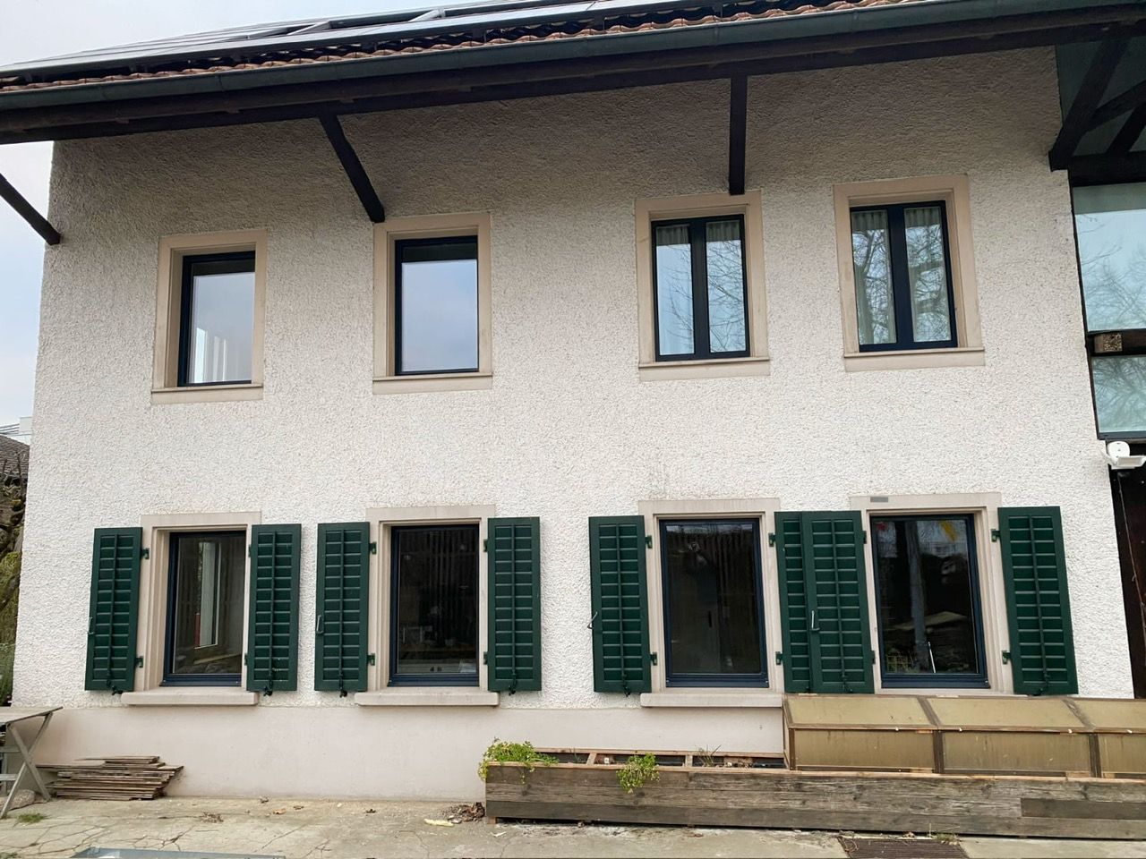 Ein weißes Haus mit grünen Fensterläden